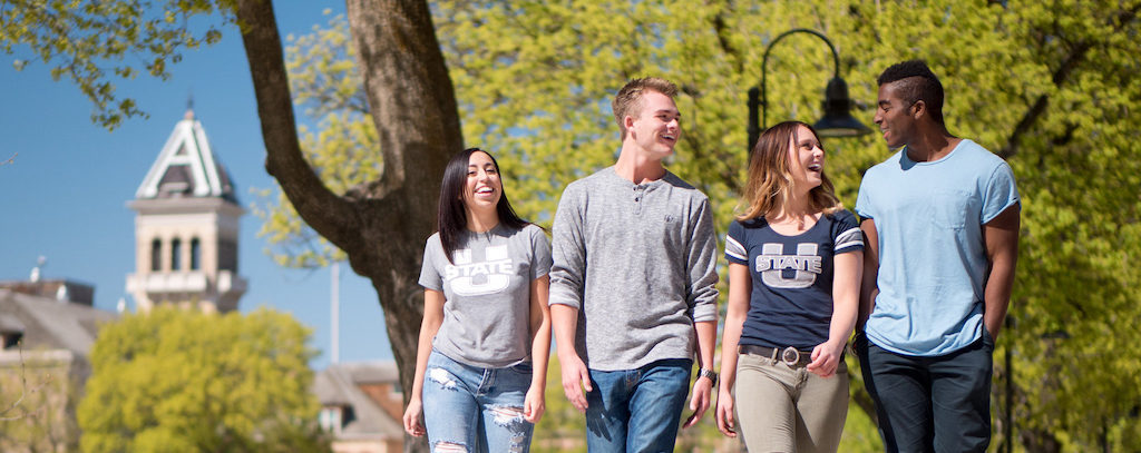 group of utah state students walking around campus